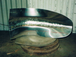 Rear Bugatti wings made in 2 pieces, this picture shows front section of rear wing on shot bag after being roughed out with a bossing mallet