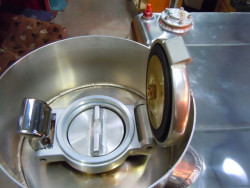 Secondary screw cap to create one way valve to meet blue book regulations.